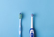 electric and classic toothbrush on a blue background