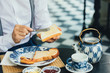 © LUMINA IMAGES - Hands of unrecognisable man putting butter on toast bread for breakfast.