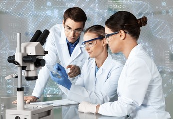 Wall Mural - Female and male scientists in glasses working with microscope