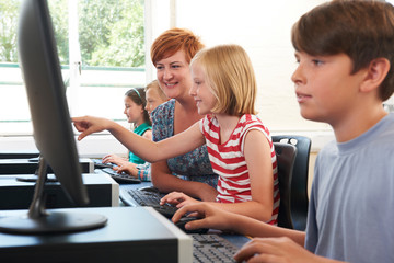 Wall Mural - Female Elementary Pupil In Computer Class With Teacher