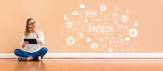 Wall Mural - Cryptocurrency fintech theme with young woman holding a tablet computer