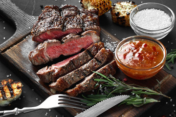 sliced grilled medium rare beef steak served on wooden board barbecue, bbq meat beef tenderloin.