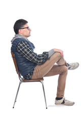 Wall Mural - portrait of a man sitting on a chair legs and arms crossed looking to the side