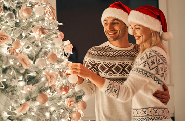 Wall Mural - The beautiful couple decorating the christmas tree