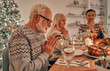 © Artem - The family sitting at the christmas table and praying