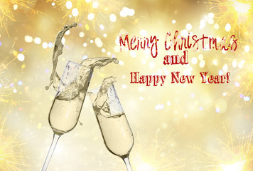 Wall Mural - Two festive champagne glasses on golden bokeh background with lights and fireworks with Merry Christmas greetings