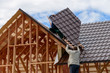 © smspsy - Masters make the roof of the frame house, metal on the roof of a new house
