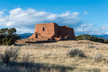 Ruins Of An Old Adobe Spanish Mission Church In A Grassy Meadow In Pecos National Historical Park Near Santa Fe, New Mexico