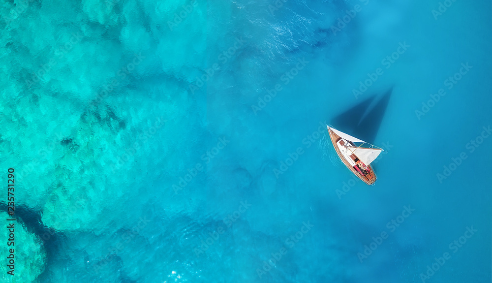 Yacht on the water surface from top view. Turquoise water background from top view. Summer seascape from air. Travel concept and idea - obrazy, fototapety, plakaty 
