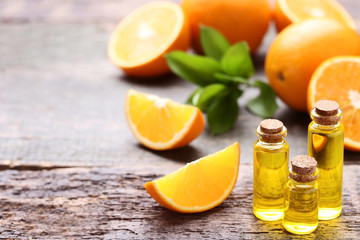 Wall Mural - Orange oil in bottles on grey wooden table