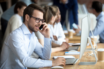 Wall Mural - confident employee talking, consulting by phone with client, sitting at workplace, customer, office 