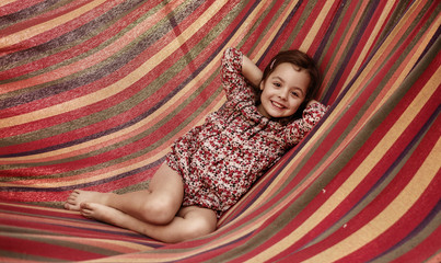 cute little girl realxing on a hammock