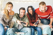 © Alessandro Biascioli - Millennial friends playing video games online with headset - Young people having fun with new trends technologies - Gaming, entertainment, fun, tech and youth lifestyle holidays