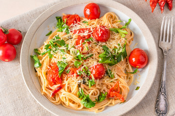 Pasta al pomodoro - spaghetti with cherry tomatoes on a plate close-up in a rustic style, top view