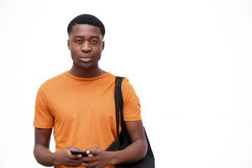 serious looking young black man with bag and mobile phone against isolated white background