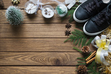 Flat Lay Black Sneaker, Mini Christmas Tree, Gold And Silver Bows, Christmas Ornaments On Wood Background, Merry Christmas Fashion Background Concept. Top View With Copy Space.