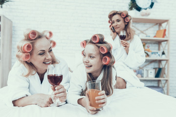 Women in White Bathrobes with Drink in Glasses.