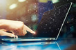 © tawanlubfah - Hand touching laptop with global network connection technology icons on screen. Future business online, worldwide communication.