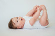 © kaloriya - Little baby lying on back and reaching to feet
