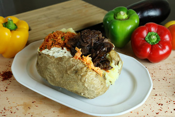 Wall Mural - Kumpir - Traditional Turkish meal with baked potato, butter, cheese, bulgur salad, kebab meat and hot spices