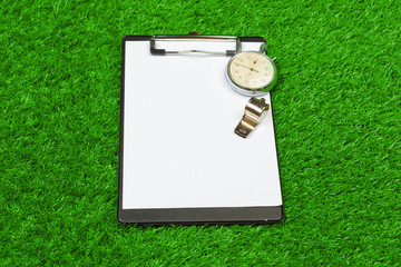 Sheet of paper and sports equipment on grass close-up