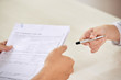 © DragonImages - Crop person giving pen to colleague for signing paper contract on business meeting
