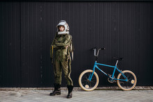 Portrait Of A Boy On A Bicycle In Street Astronaut Dress