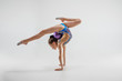 © master1305 - The teen female little girl doing gymnastics exercises isolated on a gray studio background. The gymnastic, stretch, fitness, lifestyle, training, sport concept