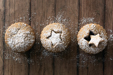 Three Gingerbread Fruit Mince Tarts Dusted With Powdered Sugar On A Wooden Background.