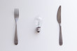 © Anna - Light bulb, fork and knife on the white table. Electricity consumption, intellectual property concept. Top view, flat lay, copy space