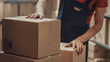 © Gorodenkoff - Warehouse Worker Collects Cardboard Boxes and Parcels of the Shelf and Puts them On Cart.