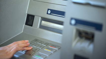 Wall Mural - Female bank client checking account balance on ATM, entering password, finance