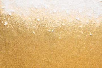 Wall Mural - white powdery snow on golden glitter background. snow and glitter for winter and christmas gift conc