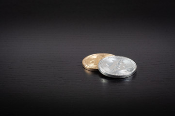 Bitcoin gold and silver coin on the black table background close-up