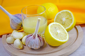 Healthy lemon drink and fresh garlic.