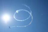 Fototapeta Sypialnia - The trail of the plane in the sky in the form of a spiral, drawings in the sky, the smoke of the plane