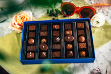 A Box Of Chocolates With Sunglasses And Roses