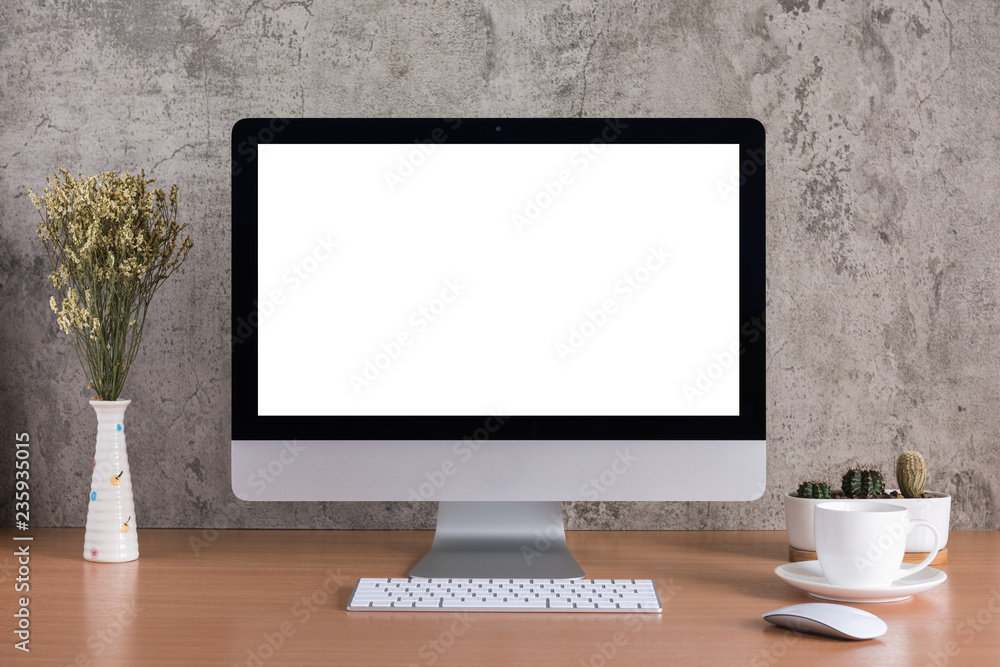 Blank screen of all in one computer with dry flowers, coffee cup and cactus vase on raw concrete background - obrazy, fototapety, plakaty 