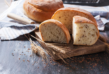 Homemade  freshly baked  bread with flax seeds  on dark wooden b