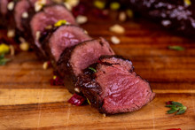 Venison Pieces On A Board With Dried Tomatoes