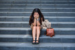 © TheVisualsYouNeed - desperate Asian Korean businesswoman crying alone sitting on street staircase suffering stress and depression crisis being victim of mobbing or fired losing her job