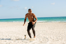 Man Running Shirtless On The Beach