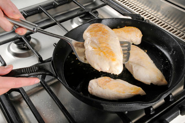 Canvas Print - WOMAN FRYING CHICKEN BREASTS IN PAN