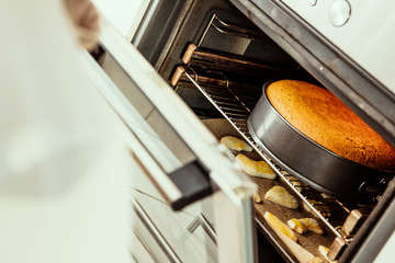 Oven's opened doors with homemade cookies and cake.