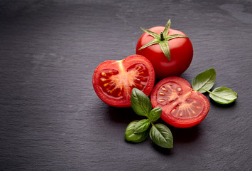 fresh  tomatoes and basil on black  stone background