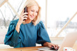 © sepy - Businesswoman making call and typing on keyboard at office