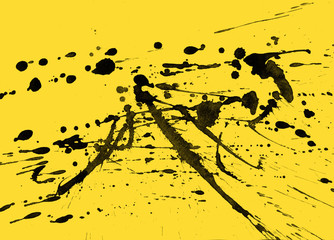 Isolated artistic black watercolor and ink paint splatter textures and decorative elements on yellow paper background.