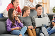 © Africa Studio - Group of teenagers with modern devices sitting on sofa indoors