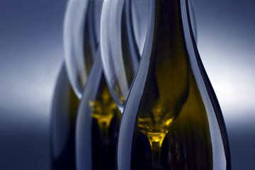 Three wine bottles and two empty wine glasses close up