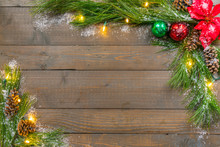 Christmas Background With Spruce Greens, Snow, Ornaments And Lights